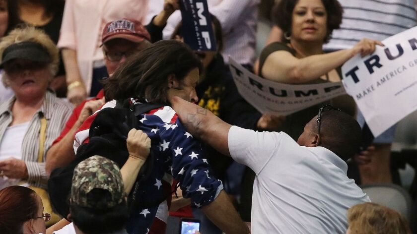 Anti-Trump protester Bryan Sanders, center left, is punched by a Trump supporter at a rally in Tucson, Ariz., on March 19, 2016.