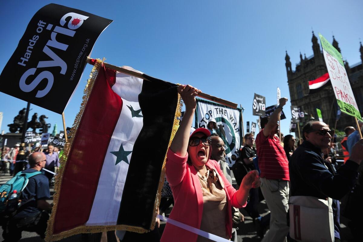 Protesters in London, some carrying the Syrian flag, demonstrate against military intervention in Syria.