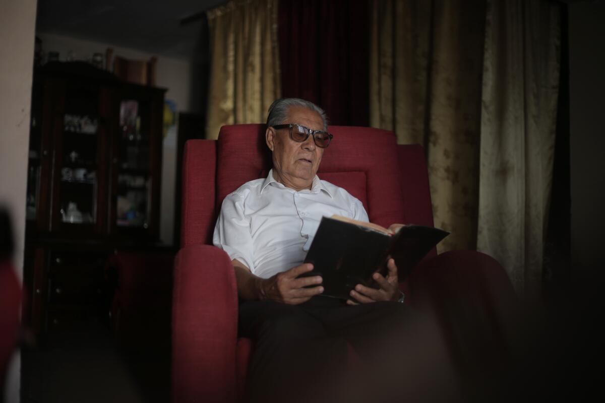 Minister Cirilo Ramirez, 77, reads in a chair