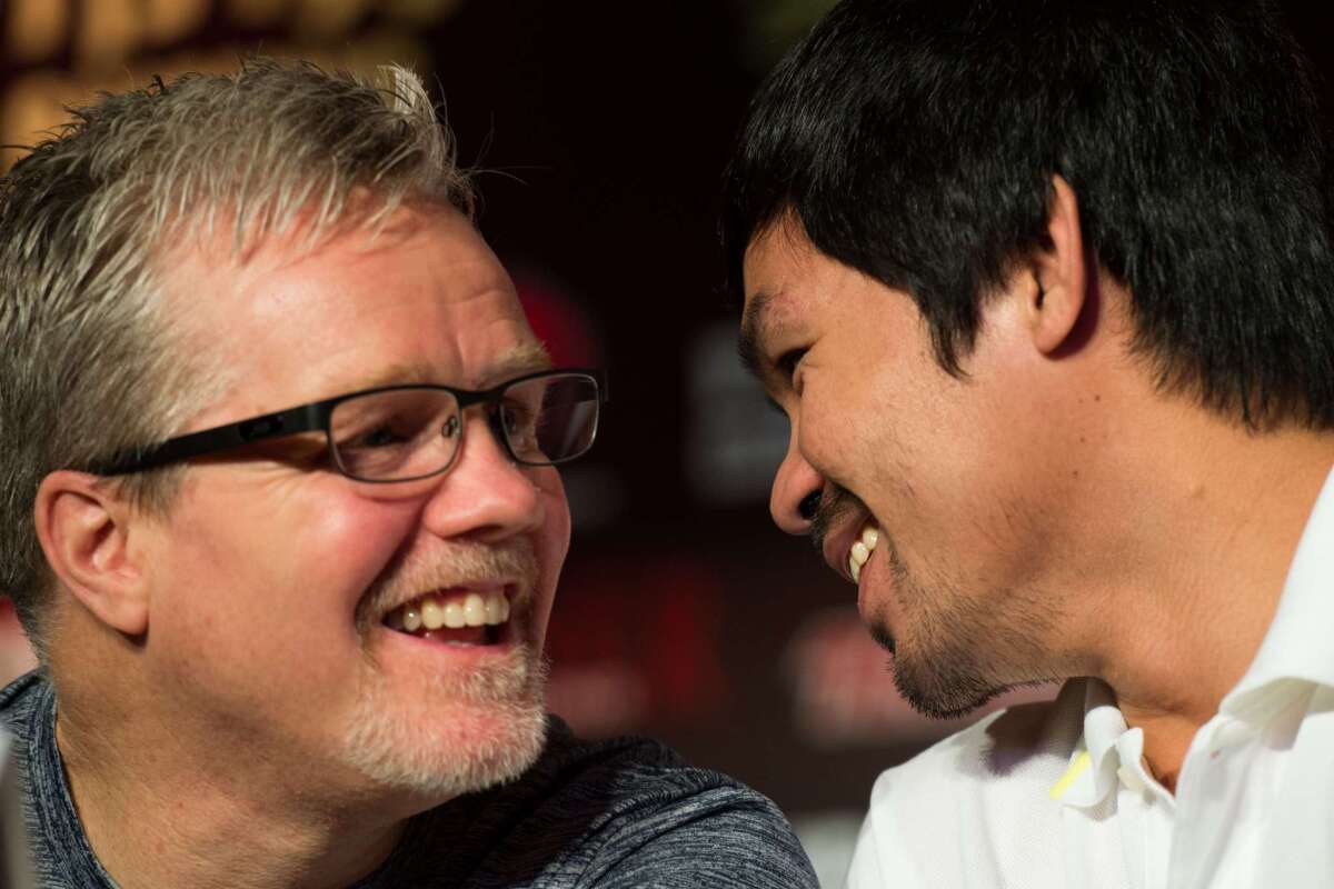Philippine boxing icon Manny Pacquiao and trainer Freddie Roach talk during a news conference in Shanghai on Aug. 26.