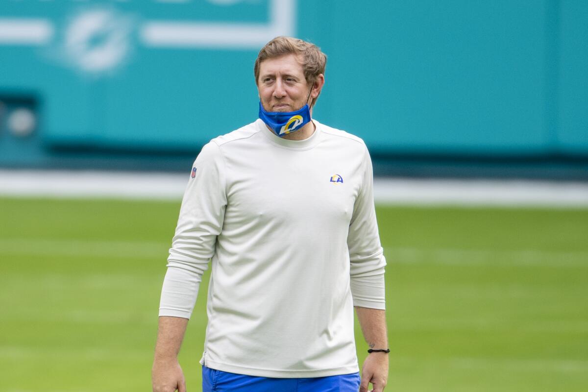 Rams assistant quarterbacks coach Liam Coen smiles on the field before a game.