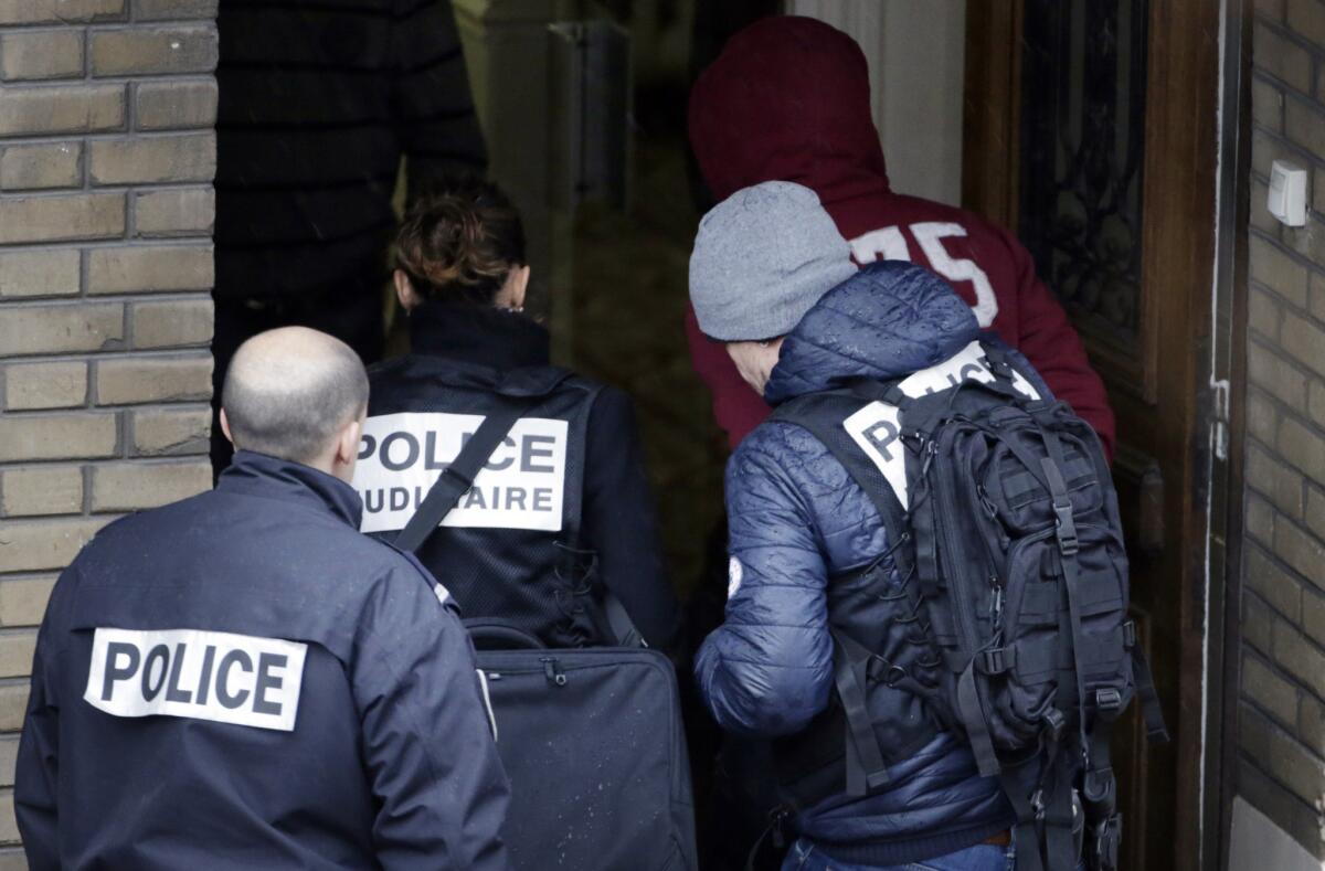 A man arrested by police is escorted in a hotel in Montrouge, a southern suburb of Paris, during investigations following the shooting of a female police officer the day after the Charlie Hebdo attack.