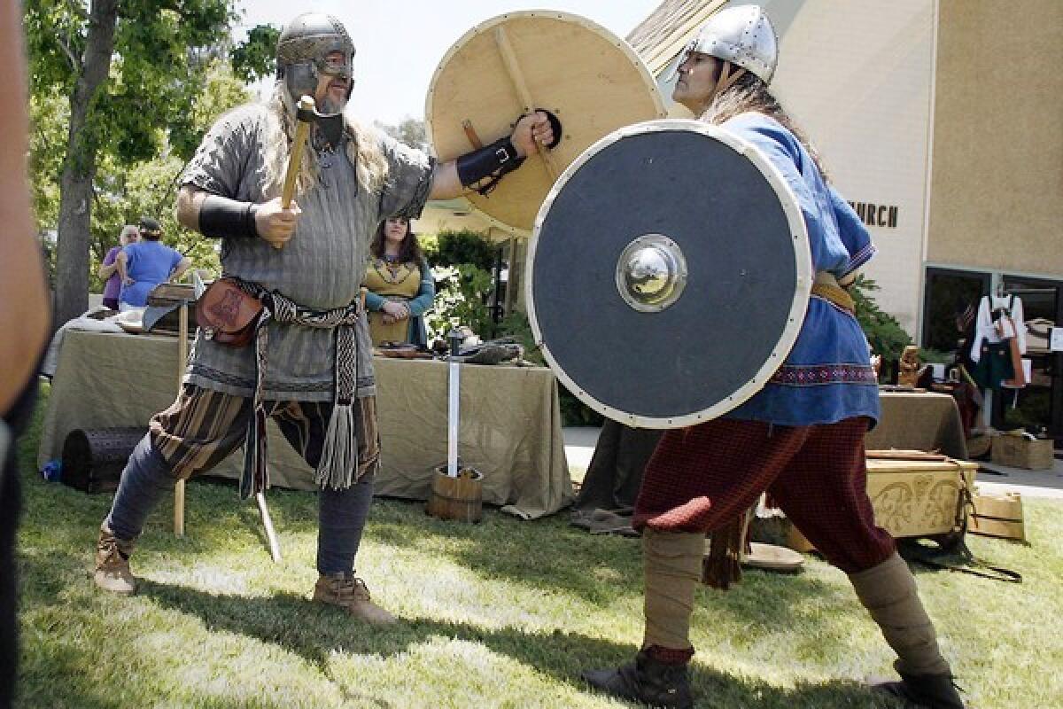 Gregg Vaughn, left, and Jaan Calderon show visitors how Vikings fought and defended themselves during Viking Fest, which took place at Lutheran Church in the Foothills in La Canada on Saturday, June 22, 2013.