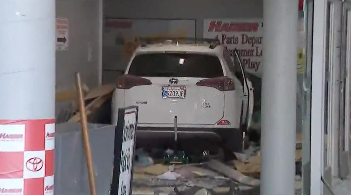 A car sits in the debris after it drove through the Hamer Toyota dealership in Mission Hills after a fatal crash.