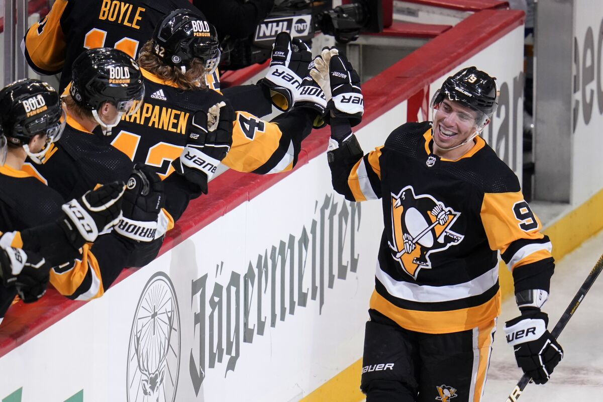 Pittsburgh Penguins' Evan Rodrigues (9) returns to the bench after scoring during the third period of an NHL hockey game against the St. Louis Blues in Pittsburgh, Wednesday, Jan. 5, 2022. The Penguins won 5-3. (AP Photo/Gene J. Puskar)