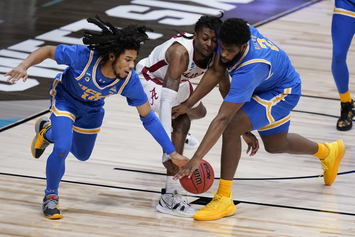 UCLA's Tyger Campbell, left, and Cody Riley battle for a loose ball with Alabama's John Petty Jr. 
