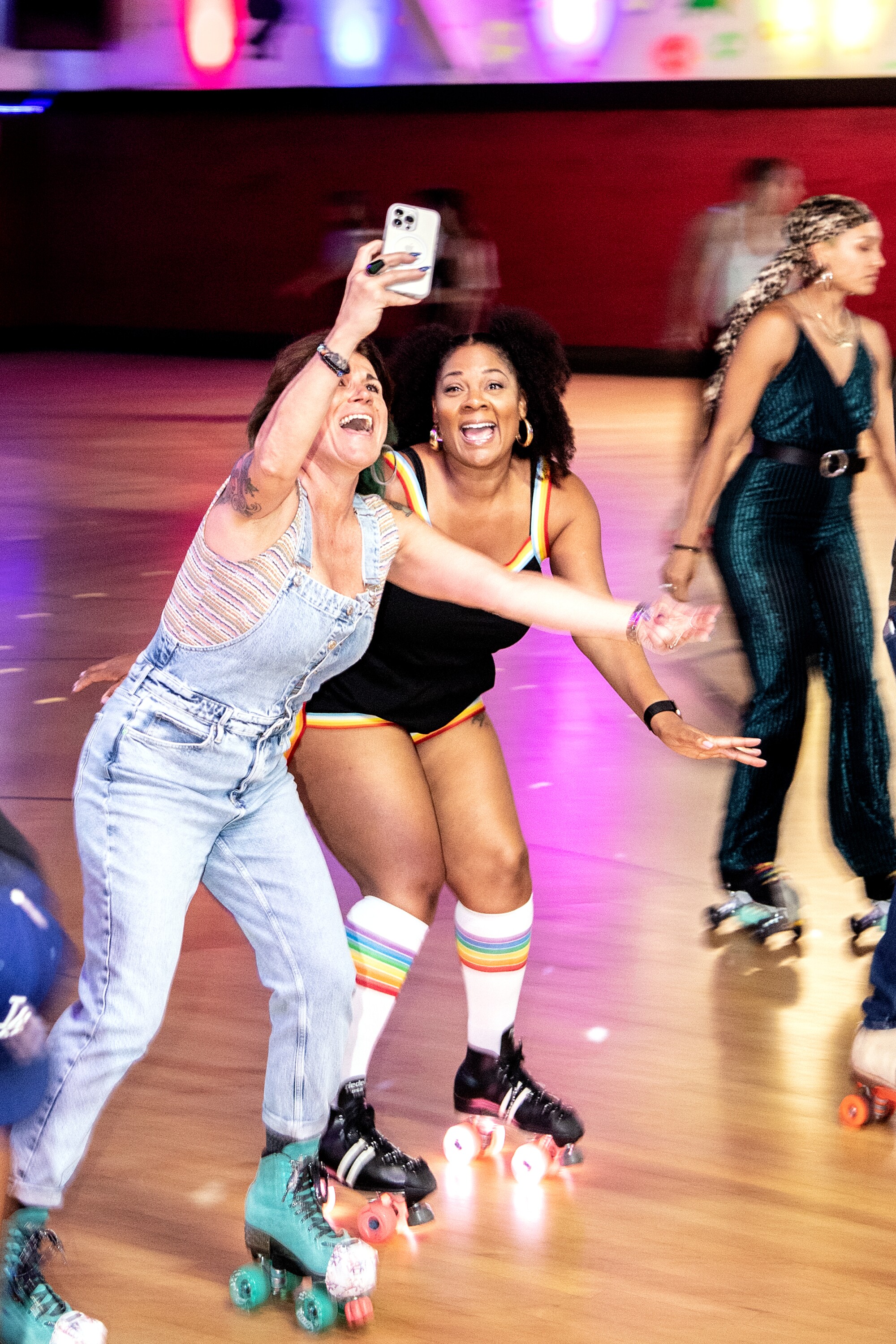 Two people skate while they take a selfie.