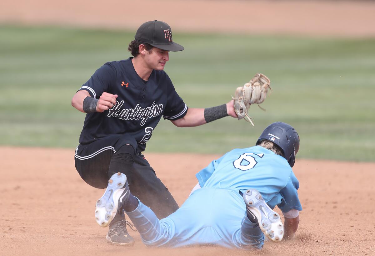 Shortstop Travis Curry (2) of Huntington Beach nails Trevor Smith (6) stealing second against El Cajon Granite Hills.