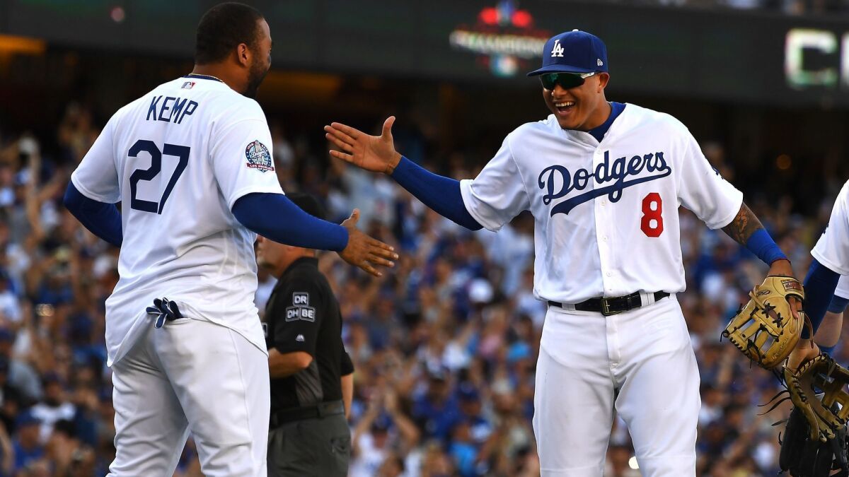 Matt Kemp, left, and Manny Machado celebrate after the Dodgers defeated the Colorado Rockies to clinch their sixth straight division championship on Oct. 1.