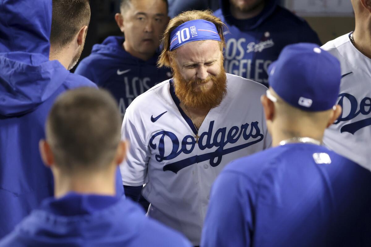 Dodgers third baseman Justin Turner walks slowly through the dugout after suffering a leg injury.