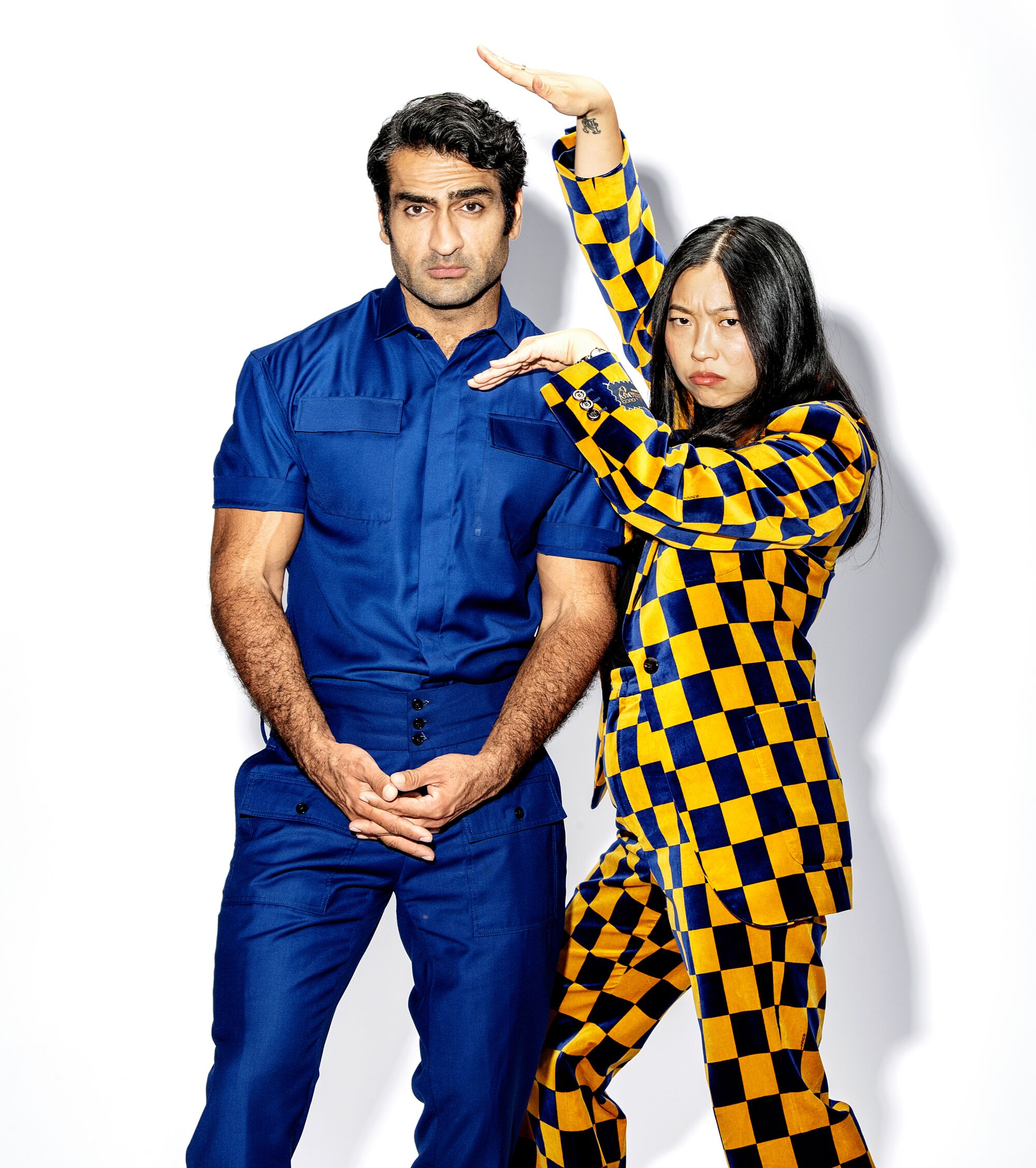 Aug. 16: Kumail Nanjiani in a blue shirt and pants next to Awkwafina in a blue and yellow checkered suit