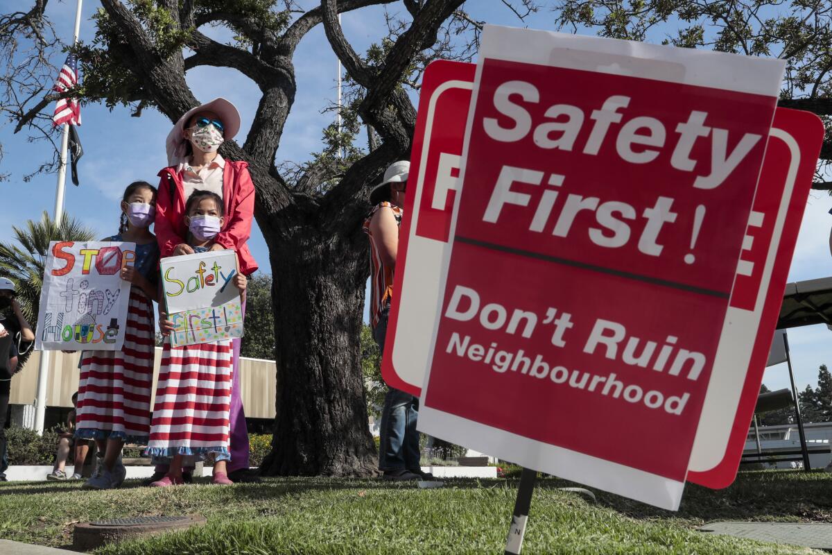 Jennifer Gnu and her daughters join dozens of others protesting a proposed tiny homes project next to Arcadia.