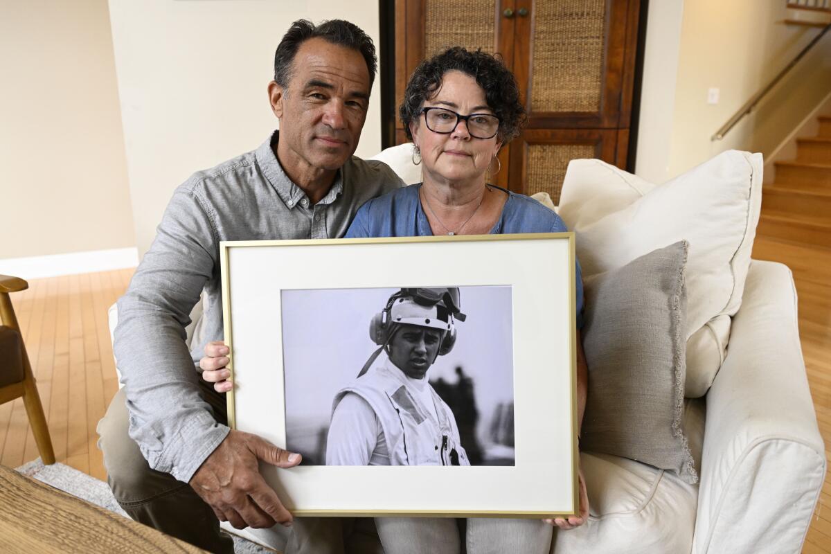 Derek and Suzi Alkonis pose with a photo of their son Lt. Ridge Alkonis.