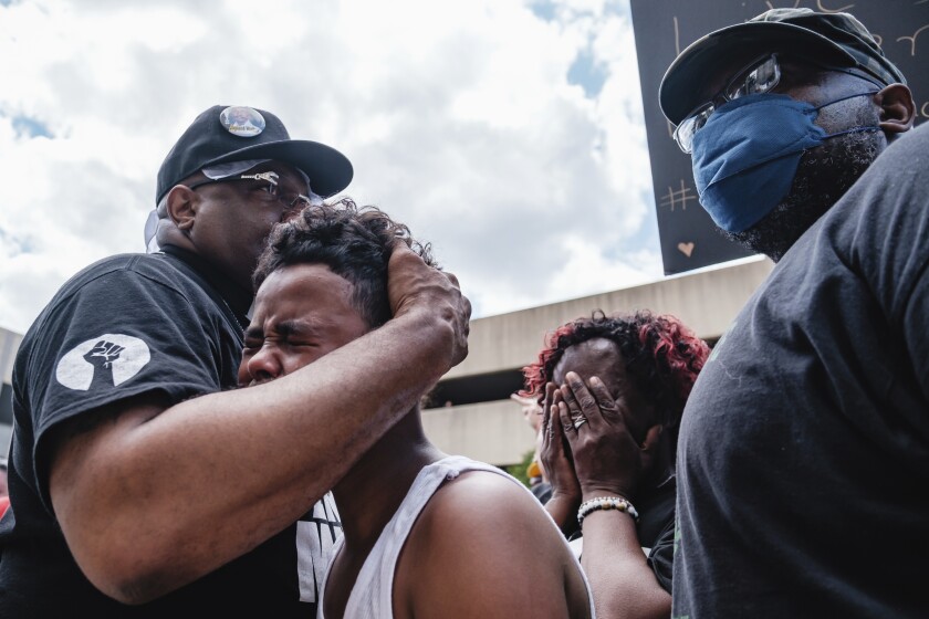 Javon Williams, 13, is comforted by Rev. Jaland Finney
