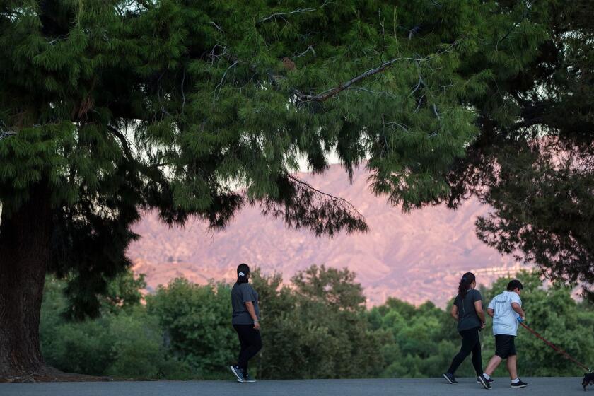 LAKE VIEW TERRACE, CA - SEPTEMBER 27, 2017: Pedestrians walks along one of the paved circular paths below the Hansen Dam on September 27, 2017 in Lake View Terrace, California.(Gina Ferazzi / Los Angeles Times)