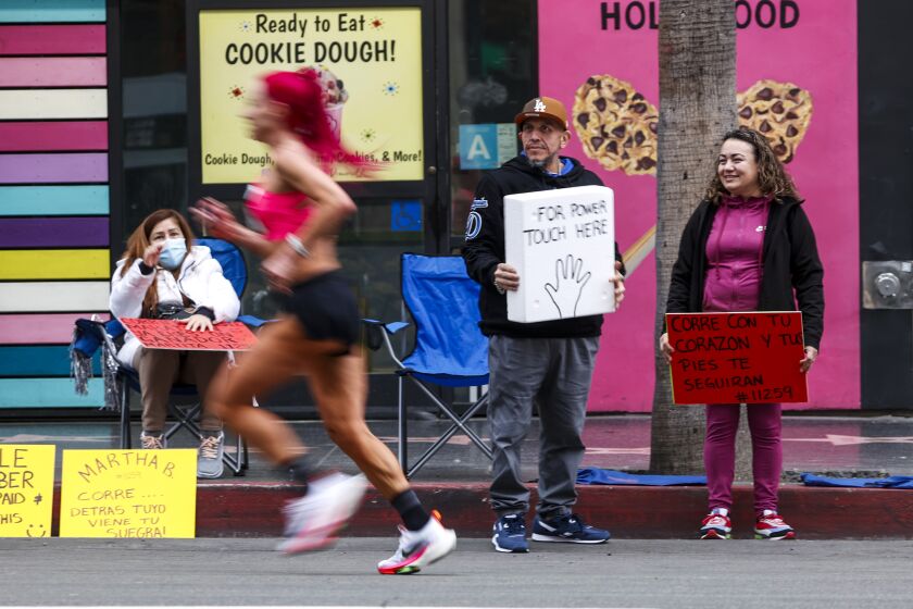 A runner runs along Hollywood Blvd during the 38th LA Marathon in Los Angeles, Sunday, March 19, 2023. (Photo by Ringo Chiu / For The Times)