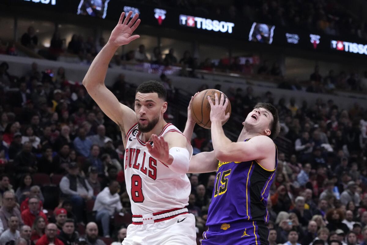 Lakers' Austin Reaves is fouled by Chicago Bulls' Zach LaVine as Reaves drives to the basket.