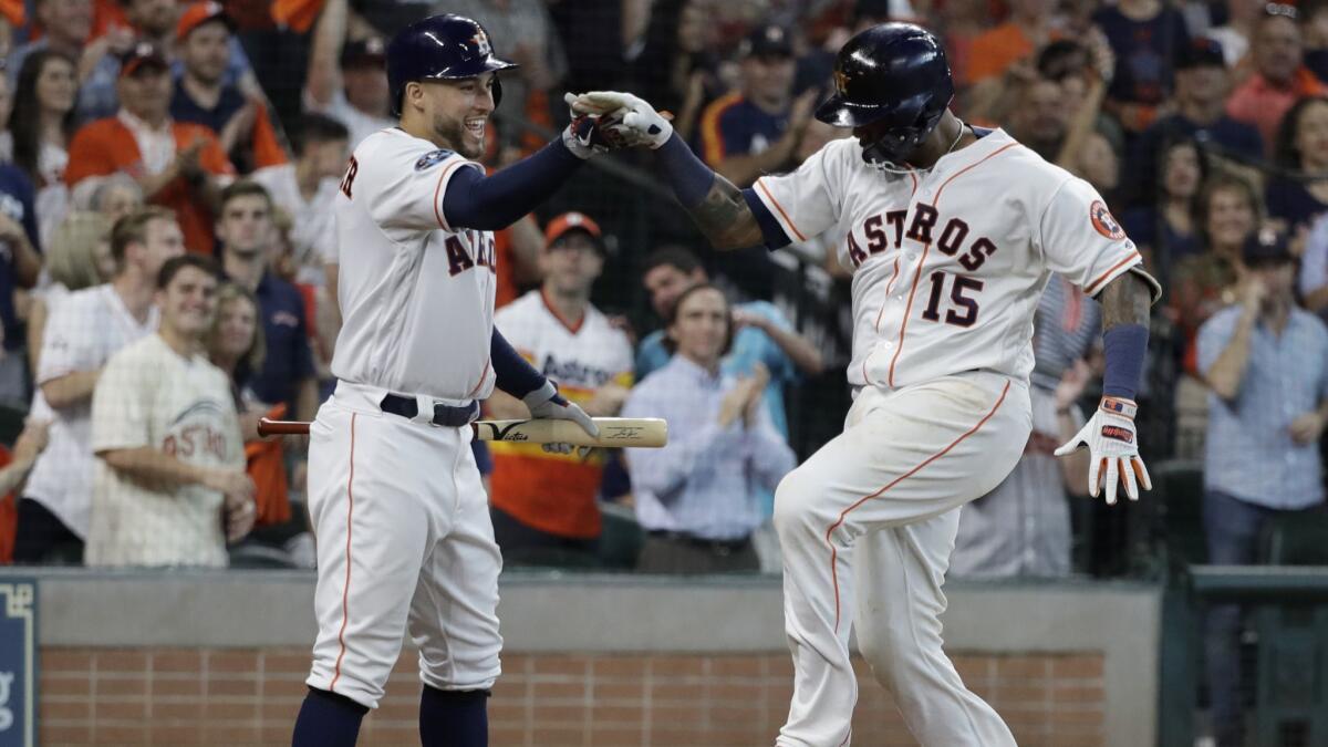 Houston Astros' Martin Maldonado (15) celebrates his solo home run against the Cleveland Indians with teammate George Springer, left, during the seventh inning in Game 1 of an ALDS on Friday in Houston.