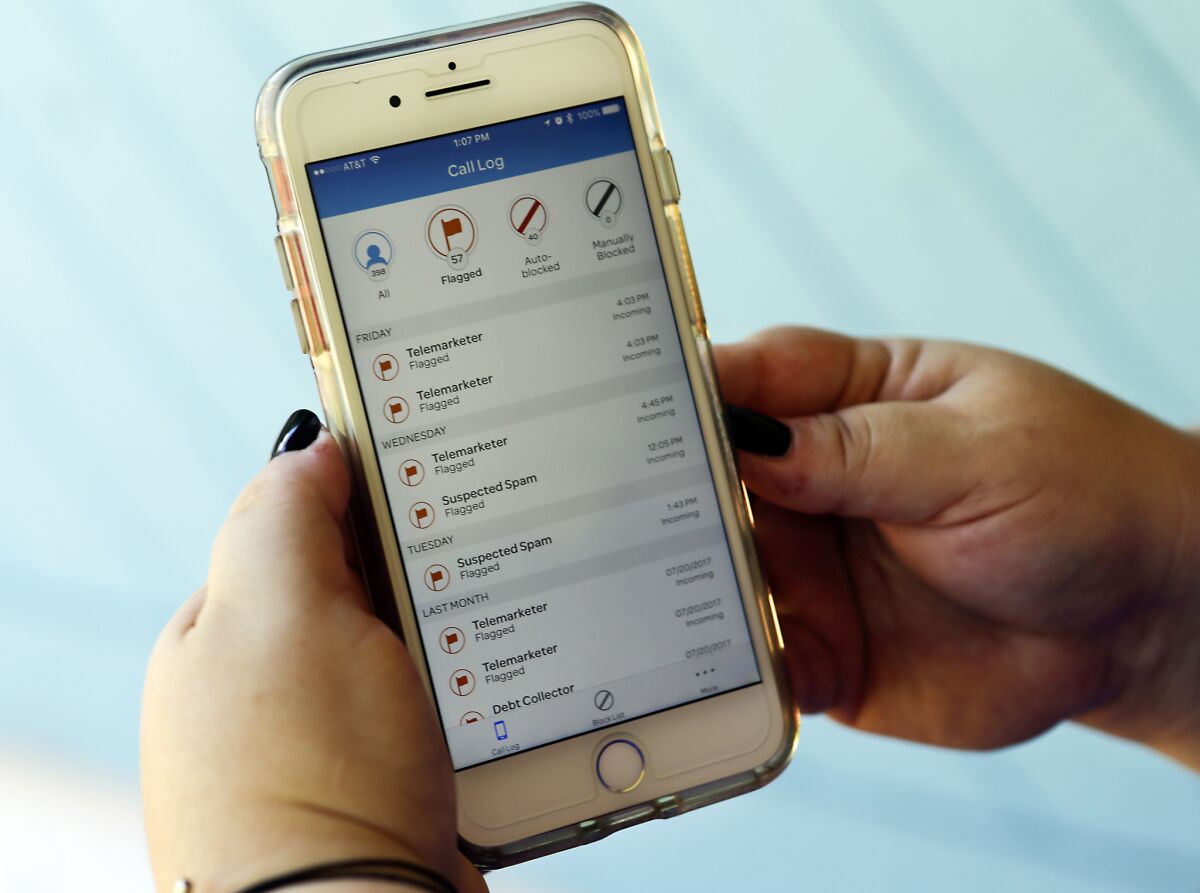 In this file photo, a consumer looks at a call log on her cellphone at her home in Orlando, Fla. The log includes numerous robocalls from telemarketers.