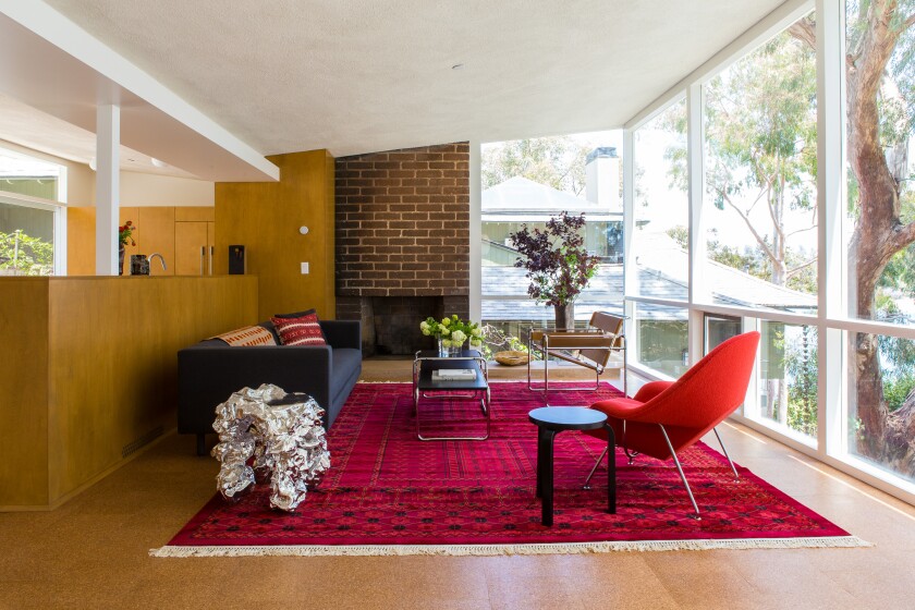 A rebuilt home in Los Angeles has a wall of windows and midcentury-modern furniture.