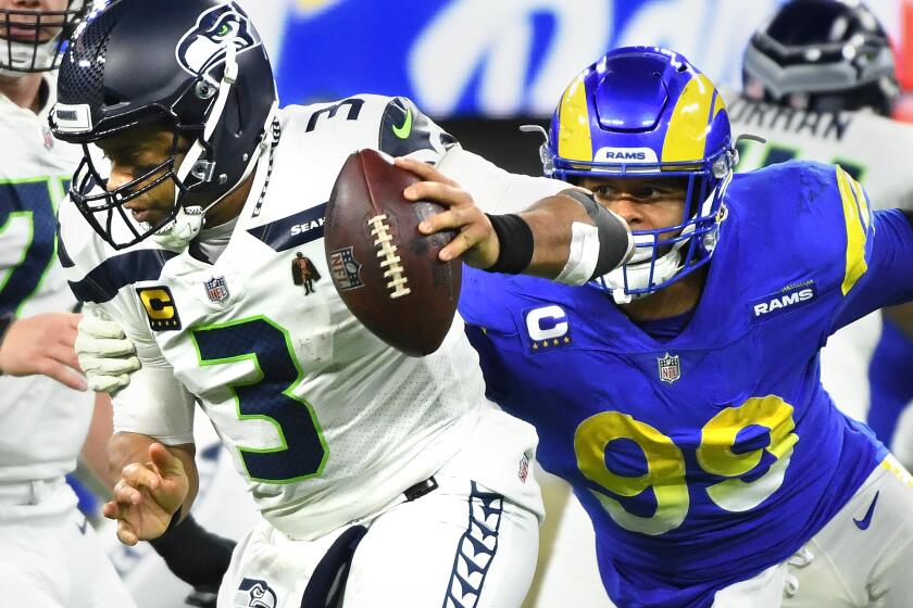 Inglewood, California December 21, 2021: Rams defensive end Aaron Donald sacks Seahawkks quarterback Russell Wilson in the fourth quarter at SoFi Stadium Tuesday in Inglewood. (Wally Skalij/Los Angeles Times)