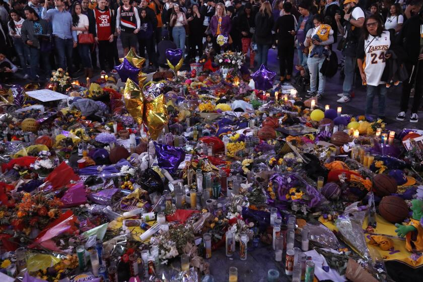 LOS ANGELES, CA - JANUARY 31, 2020 - Fans of Kobe Bryant visit an ever growing memorial for the Lakers star at LA Live in downtown Los Angeles on January 31, 2020. (Genaro Molina / Los Angeles Times)