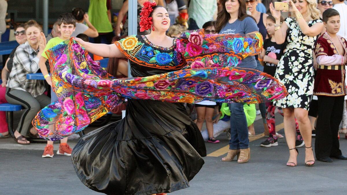 A dancer with Carolina Russek Dance Co. performs at Balboa Elementary School for the International Day Festival in Glendale on Friday. Bands and dancers entertained the attendees, and there were about a dozen vendors selling soaps, artwork, colored sand and food.