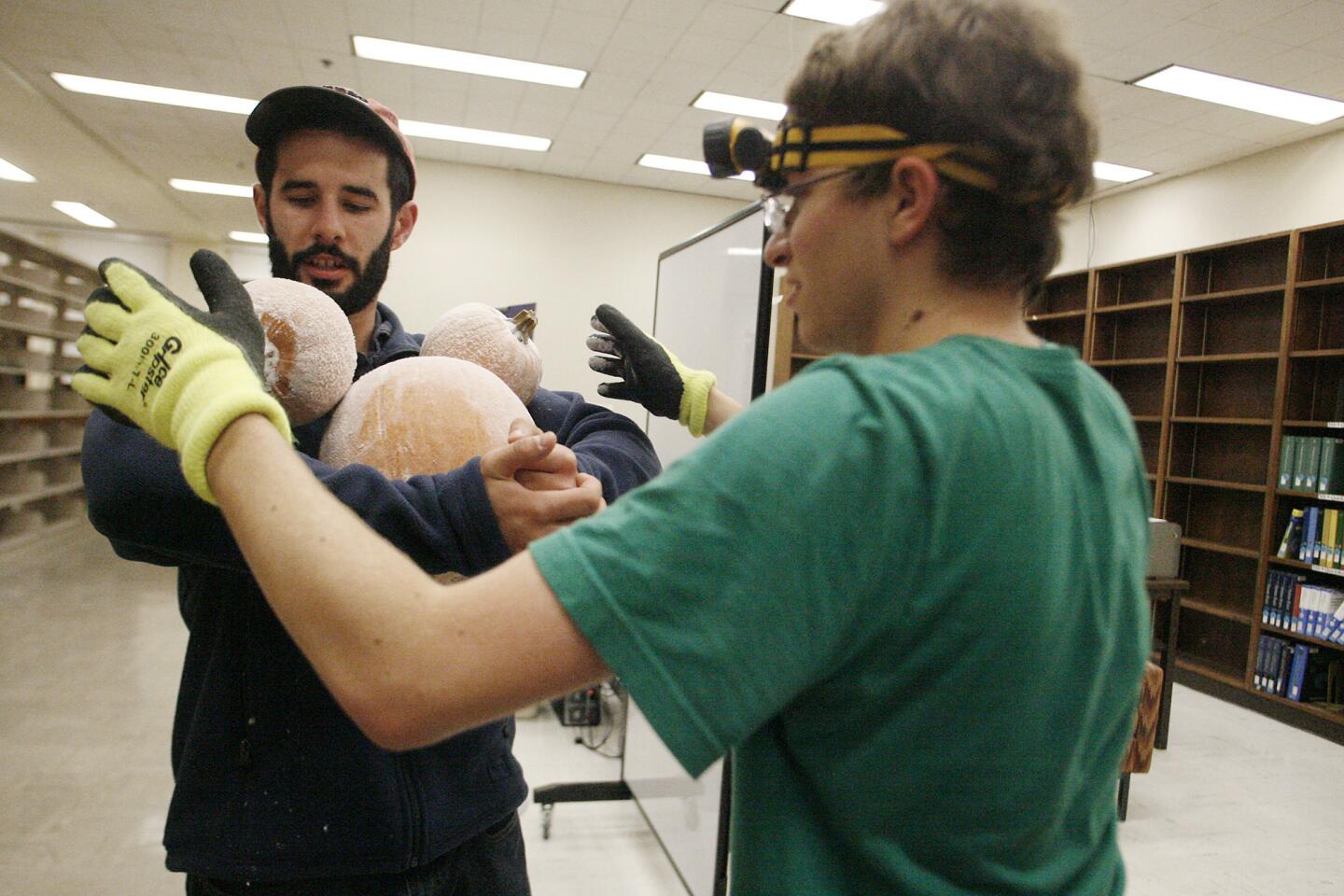Nicholas Schiefer, right, helps Matt Coggon unload over 400 pumpkins during Caltech's Annual Halloween Pumpkin drop, which took place at the Caltech's Millikan Library in Pasadena on Wednesday, October 31, 2012.