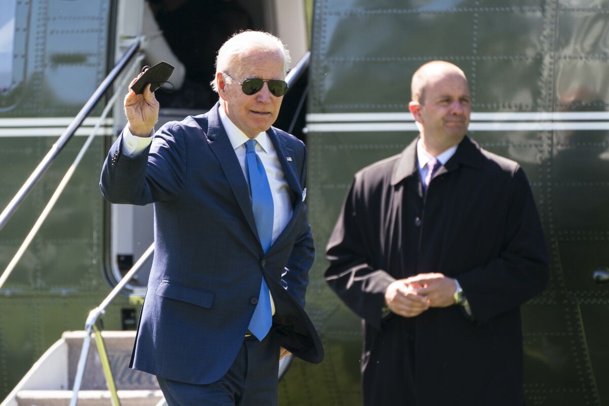 President Joe Biden waves as he walks past a U.S. Secret Service agent upon arrival at the White House from a weekend trip to his Delaware home, Monday, May 9, 2022, in Washington. (AP Photo/Manuel Balce Ceneta)