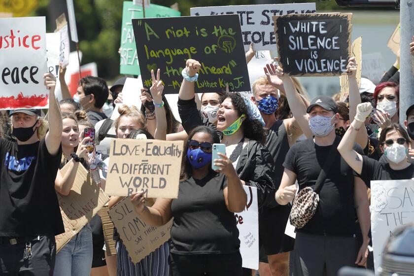 Protesters chant slogans during a Black Lives Matter protest at MacArthur Boulevard and East Coast Highway in Newport Beach on Wednesday.