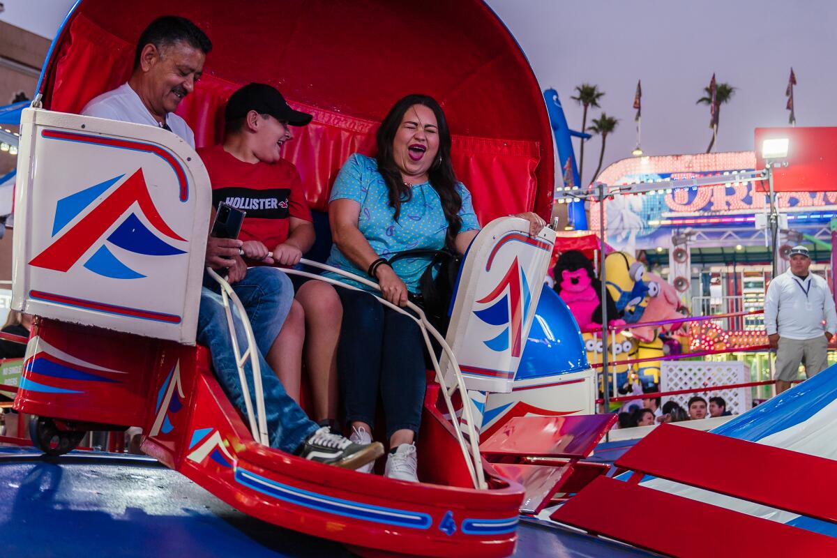 People ride the Tilt-A-Whirl at the San Diego County Fair 