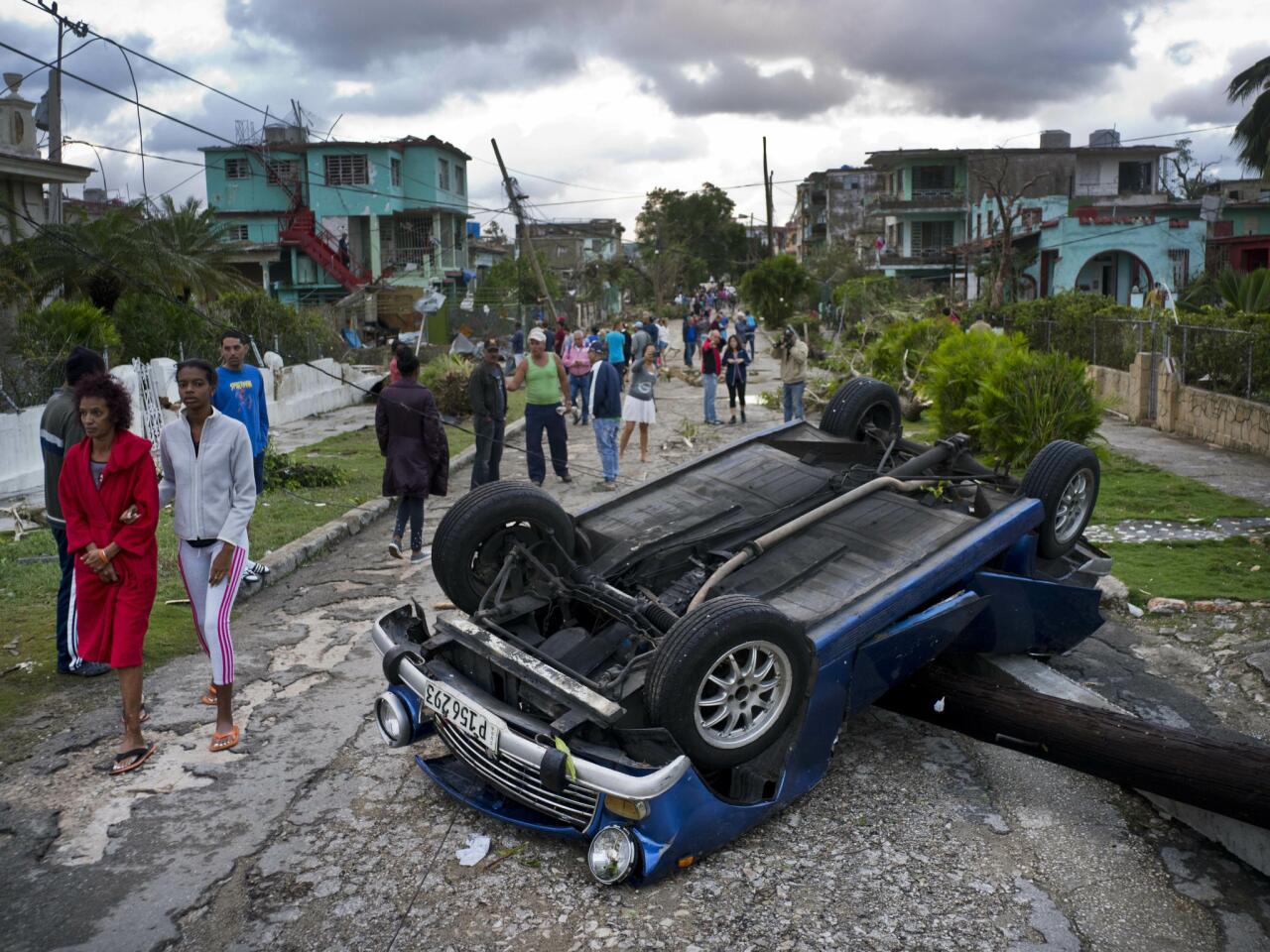 A car overturned by a tornado lies atop a utility pole in Havana. A tornado and pounding rains smashed into the eastern part of Cuba's capital overnight.