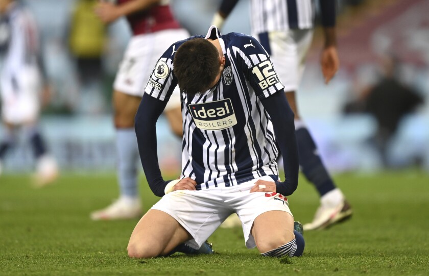 West Bromwich Albion's Okay Yokuslu sits on the pitch in dejection at the end of the English Premier League soccer match between Aston Villa and West Bromwich Albion at Villa Park Stadium in Birmingham, England, Sunday, April 25, 2021. (Shaun Botterill/Pool via AP)