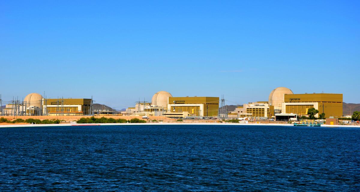 Three radiation containment domes sit alongside an evaporation pond at Palo Verde Generating Station south of Tonopah, Ariz.