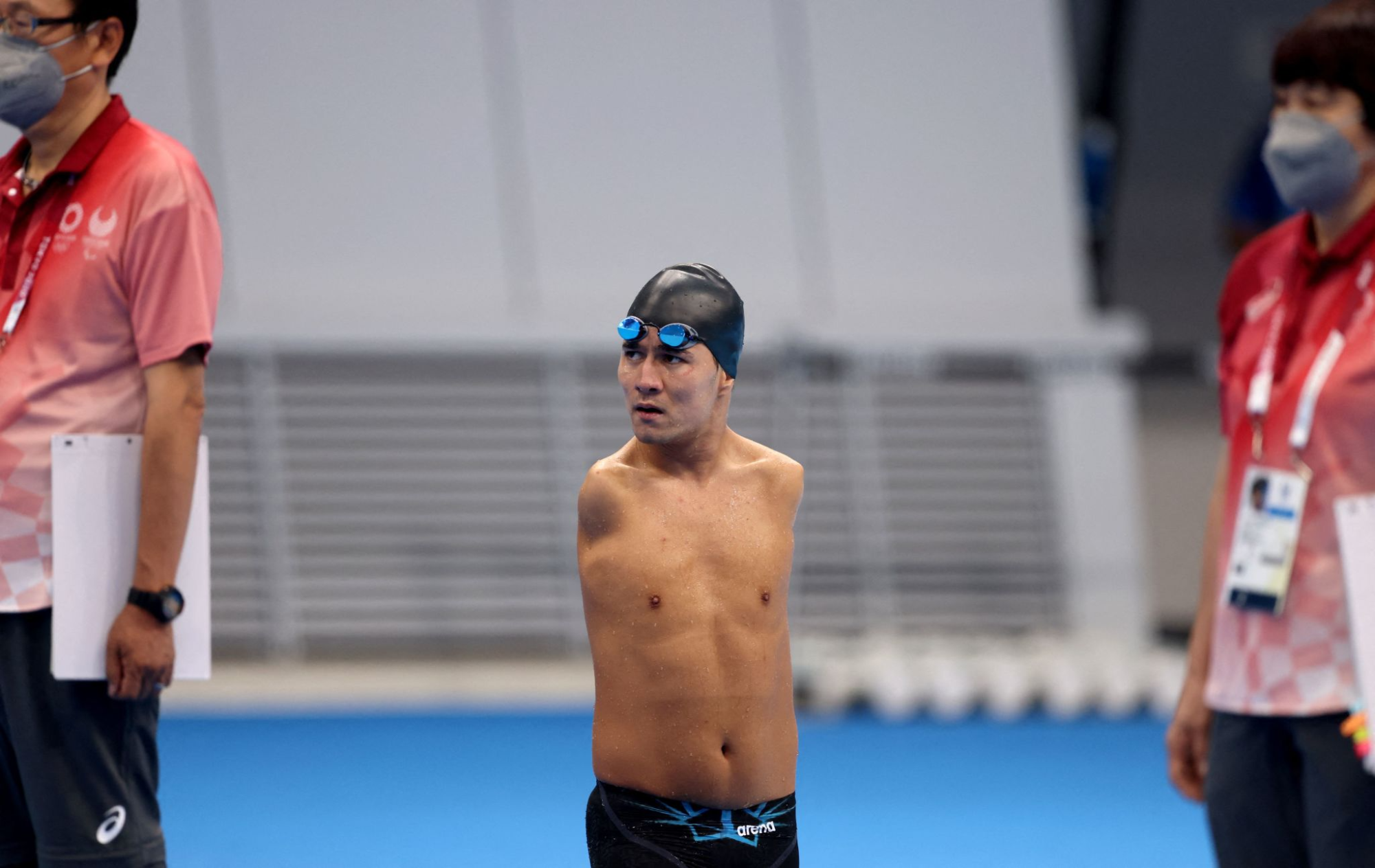 Refugee Paralympic Team's Abbas Karimi looks at the scoreboard after competing in the men's 50-meter butterfly.