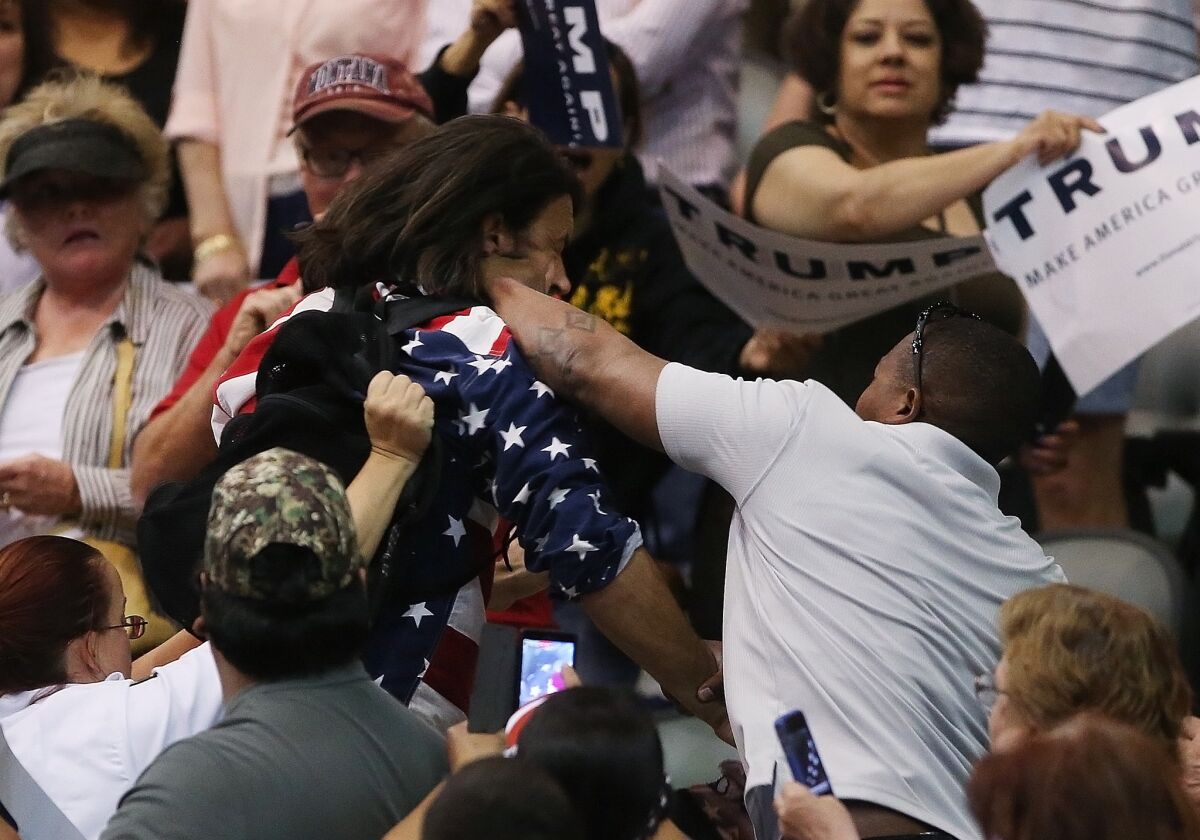 Protester Bryan Sanders, center left, is punched by a supporter of Donald Trump as he is escorted out of Republican presidential candidate's rally at the Tucson Arena on March 19.