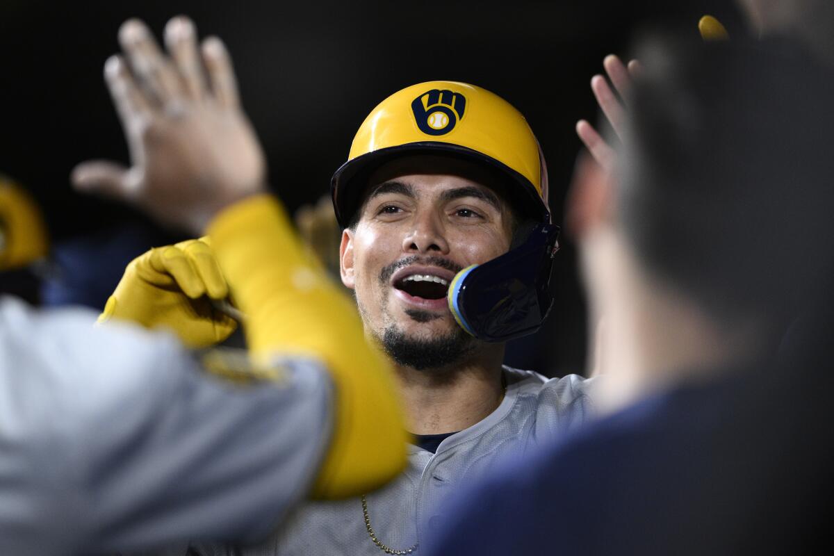 Milwaukee Brewers' Willy Adames is congratulated in the dugout after his three-run home run against the Baltimore Orioles during the fifth inning of a baseball game Friday, April 12, 2024, in Baltimore. (AP Photo/Nick Wass)