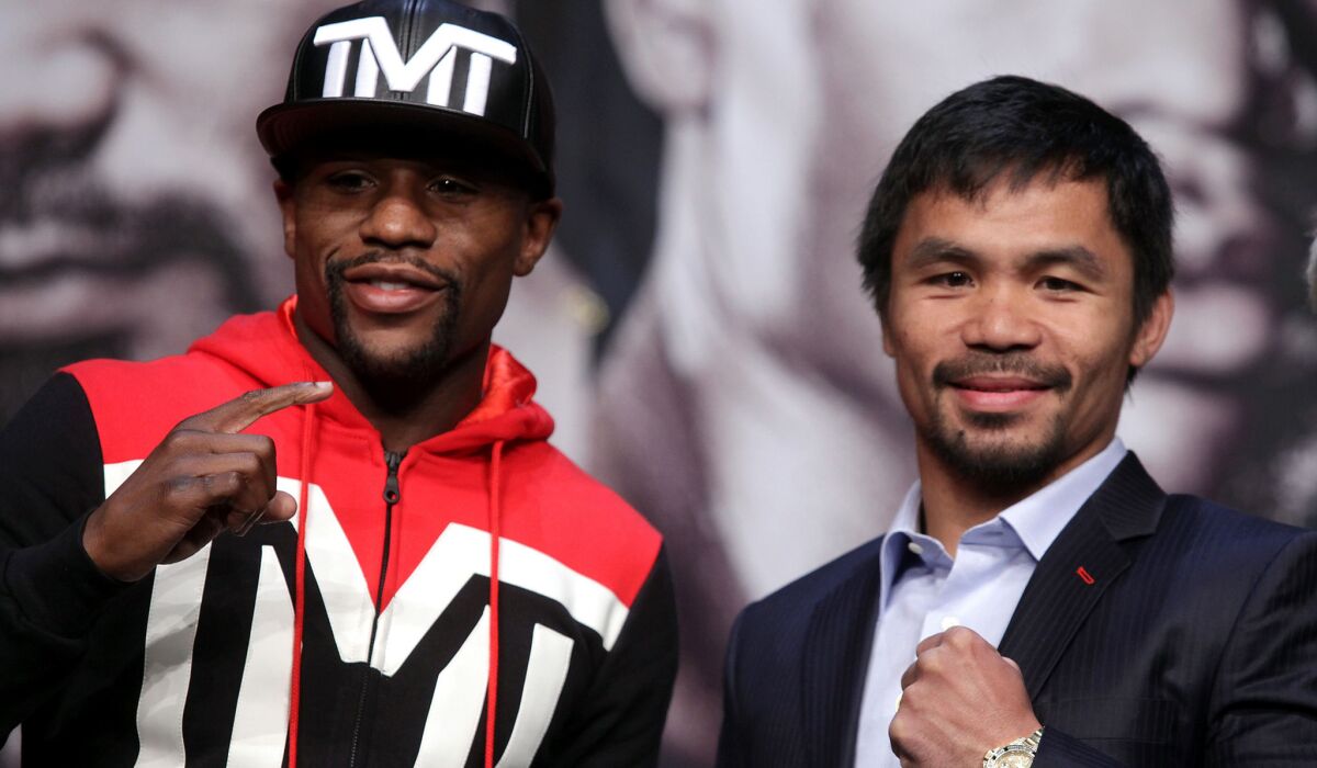 Floyd Mayweather Jr., left, and Manny Pacquiao pose for the media after their news conference on Wednesday at the MGM Grand Hotel.
