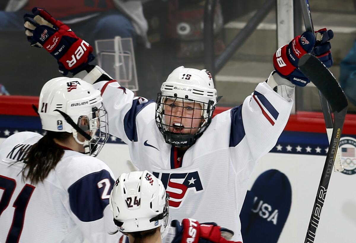 Team USA's Kelli Stack, right, celebrates with teammates Hilary Knight, left, and Josephine Pucci, bottom, after scoring during the first period of the United States' 3-2 win over Canada on Saturday.