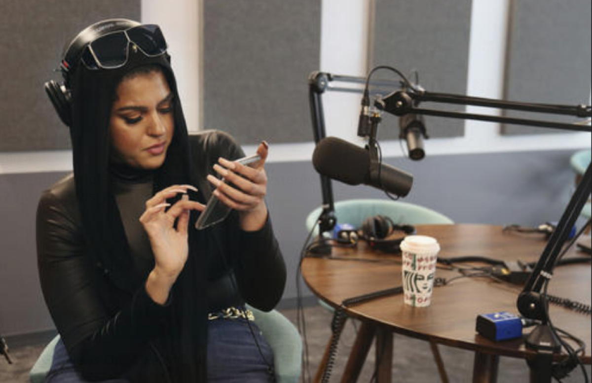 Amani Al-Khatahtbeh, fundadora de Muslimgirl.com, comprueba las notificaciones en su teléfono mientras está sentada en un estudio de grabación de Spotify, en Nueva York. (Foto AP/Jessie Wardarski)