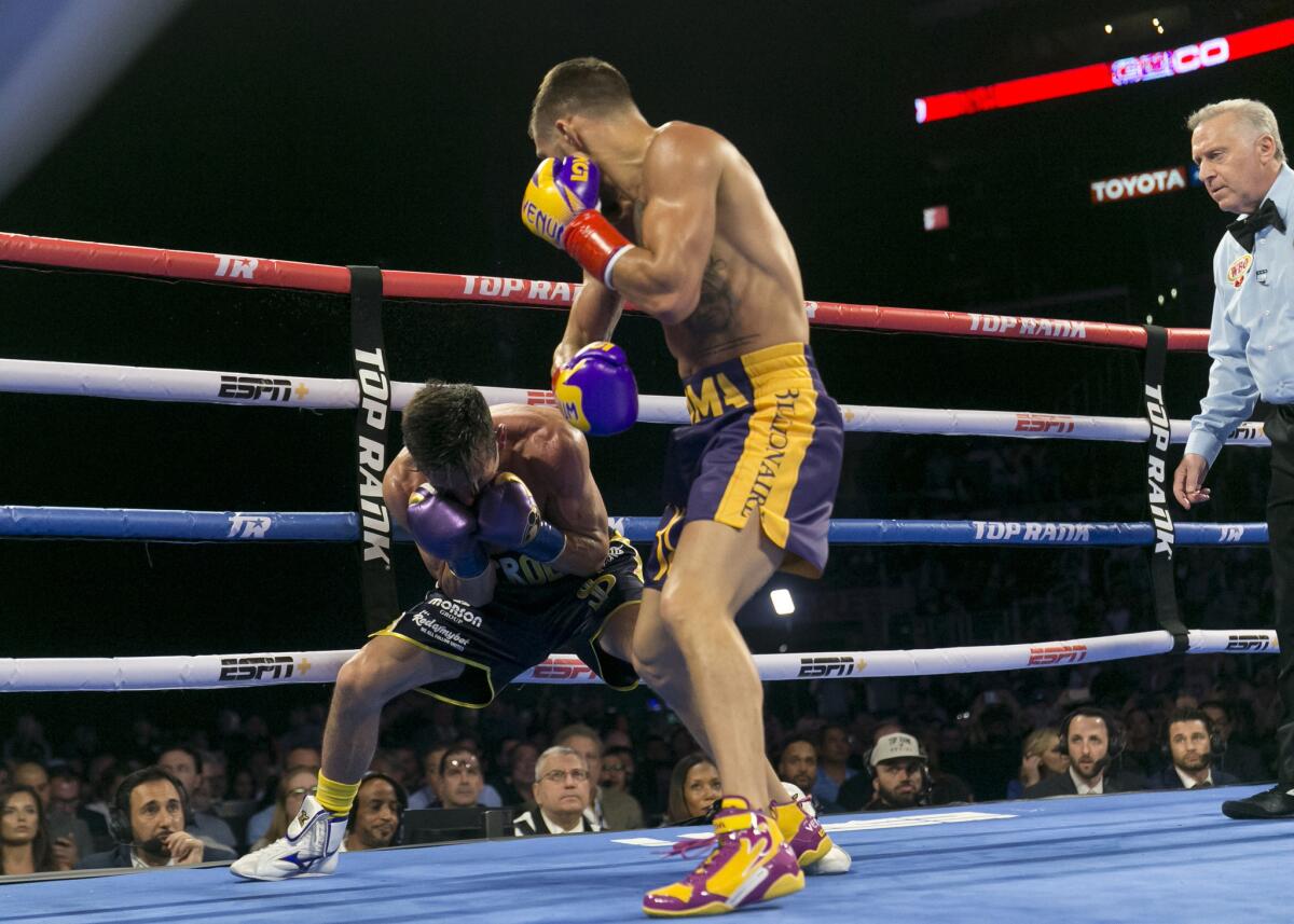 Vasiliy Lomachenko, right, knocks down Anthony Crolla in the fourth round of the WBA and WBO lightweight title boxing bout Friday at Staples Center