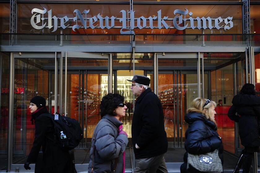 People walk by an entrance to the New York Times on March 8, 2011.