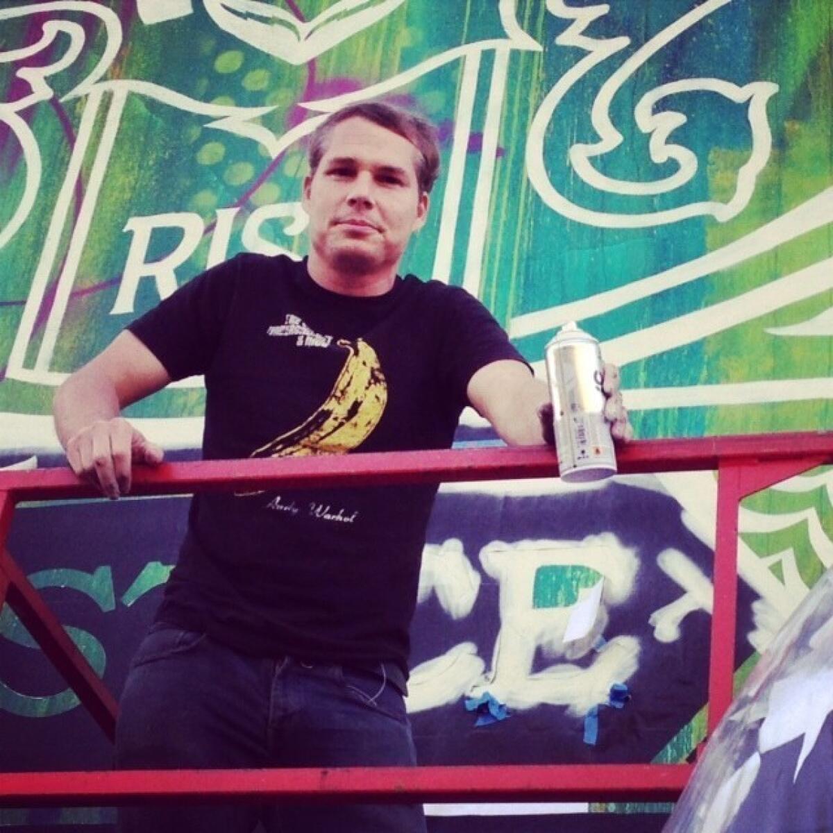 Shepard Fairey on a break from stenciling a mural that he's creating on L.A.'s skid row with fellow street artist RISK.