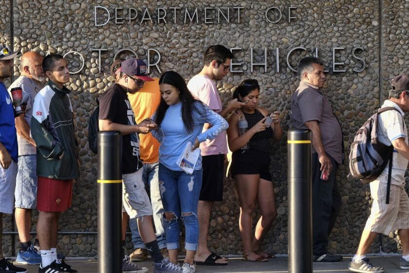 FILE - In this Aug. 7, 2018, file photo, people line up at the California Department of Motor Vehicles prior to opening in the Van Nuys section of Los Angeles. An audit issued by California Department of Finance and released on Wednesday, March 27, 2019, say the DMV didn't properly prepare for customers seeking to get new federally approved drivers' licenses, leading to hours-long wait times. (AP Photo/Richard Vogel, File)