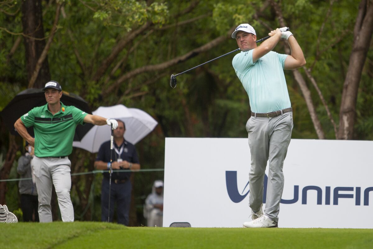 Viktor Hovland of Norway looks on as Tom Hoge of the U.S. tees off on the 1st Hole during the final round of the PGA Tour Mayakoba Golf Classic, in Playa del Carmen, Mexico, Sunday, Dec. 6, 2020. (AP Photo/Robert Fedez)