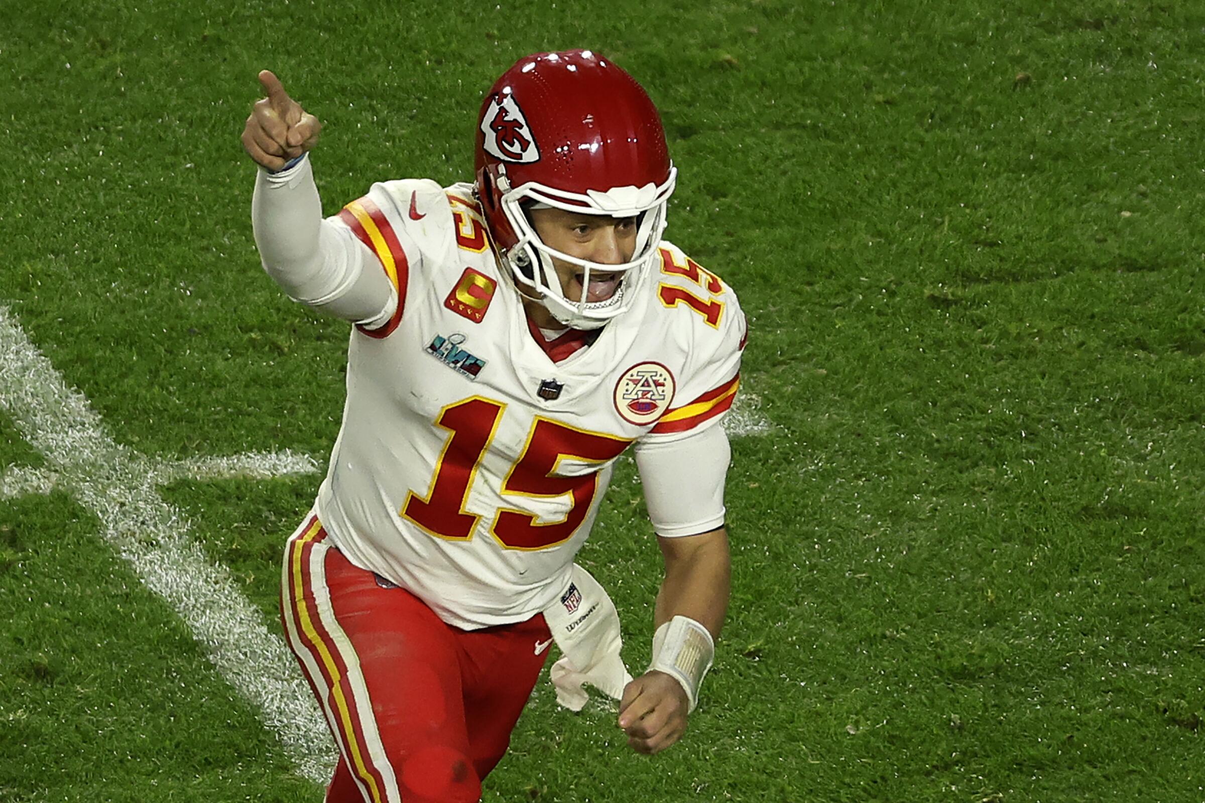 Kansas City Chiefs quarterback Patrick Mahomes raises his right arm to signal No. 1 after throwing a touchdown pass.