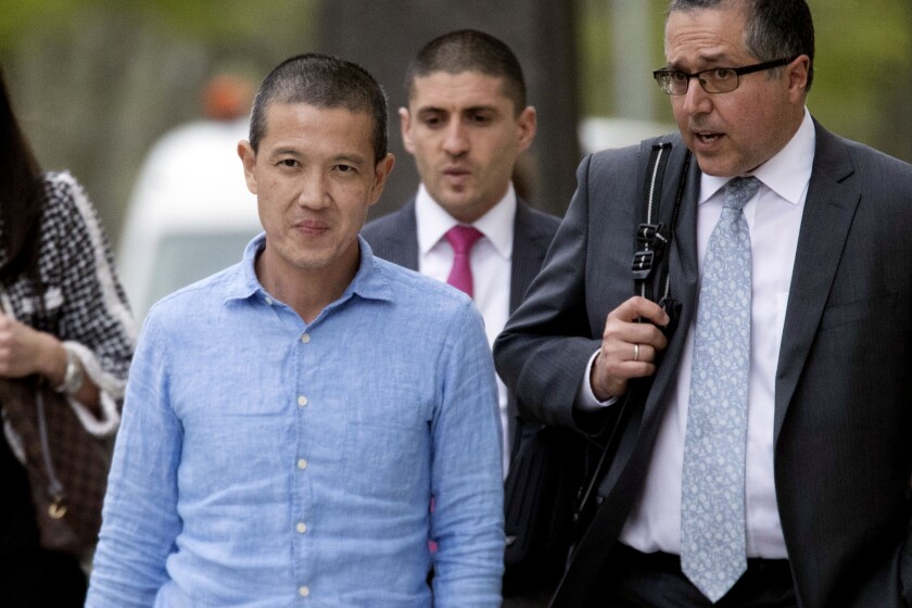 FILE - Former Goldman Sachs executive Roger Ng, left, leaves Brooklyn Federal court with attorney Marc Agnifilo, right, May 6, 2019, in New York. A jury began deliberations on Tuesday, April 5, 2022, at a U.S. trial stemming from an audacious scheme involving former Goldman Sachs bankers to ransack a Malaysian state investment fund known as 1MBD. (AP Photo/Mary Altaffer, File)