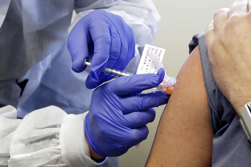 A subject receives a shot in a vaccine trial