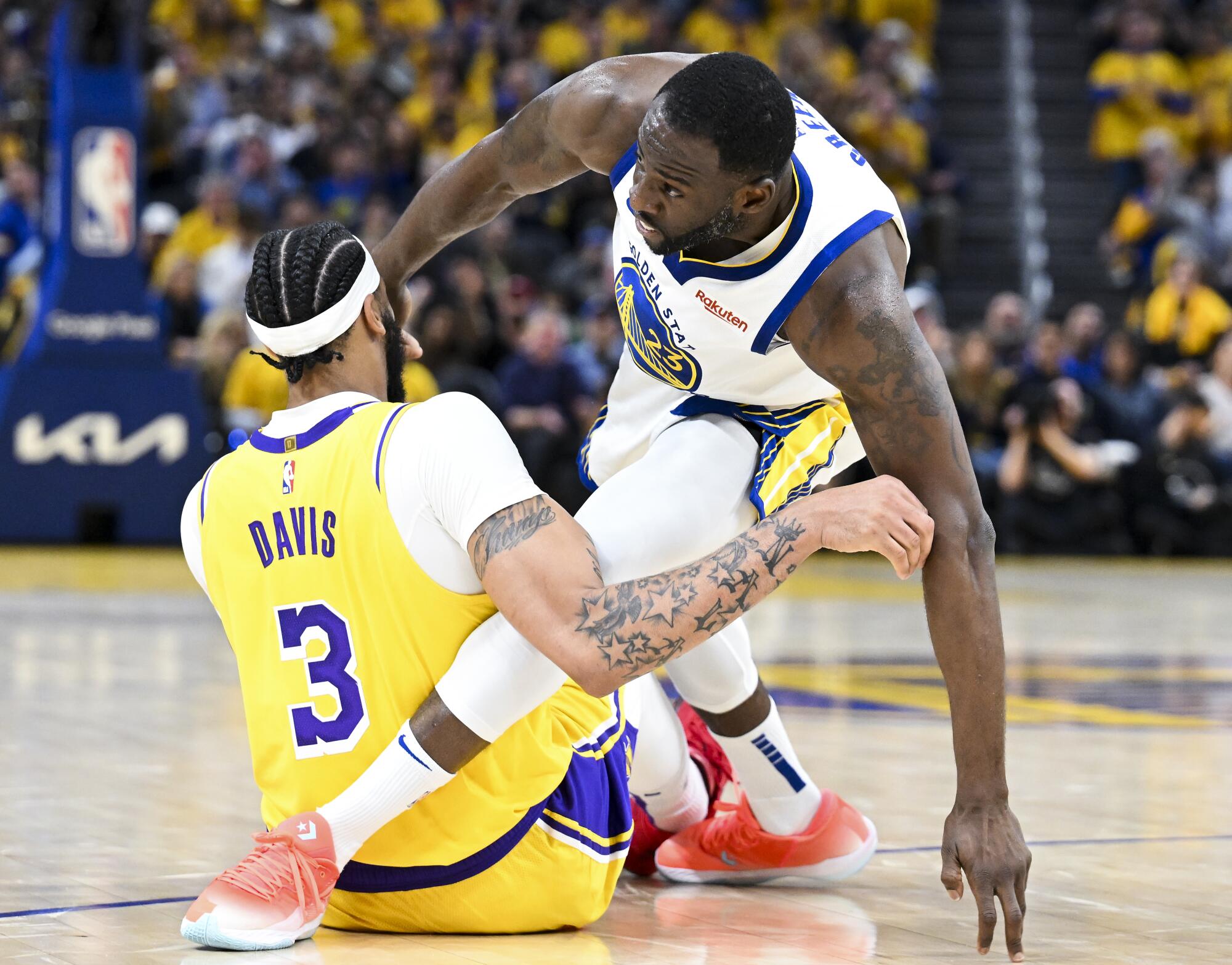 Lakers forward Anthony Davis and Warriors forward Draymond Green get tangled on the court.