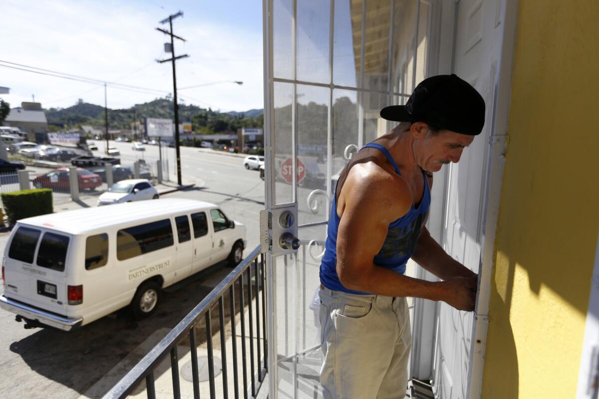 Dave Curry locks his door to his new apartment in Sunland. After a decade in the riverbed, Curry was ready to try living under a roof.